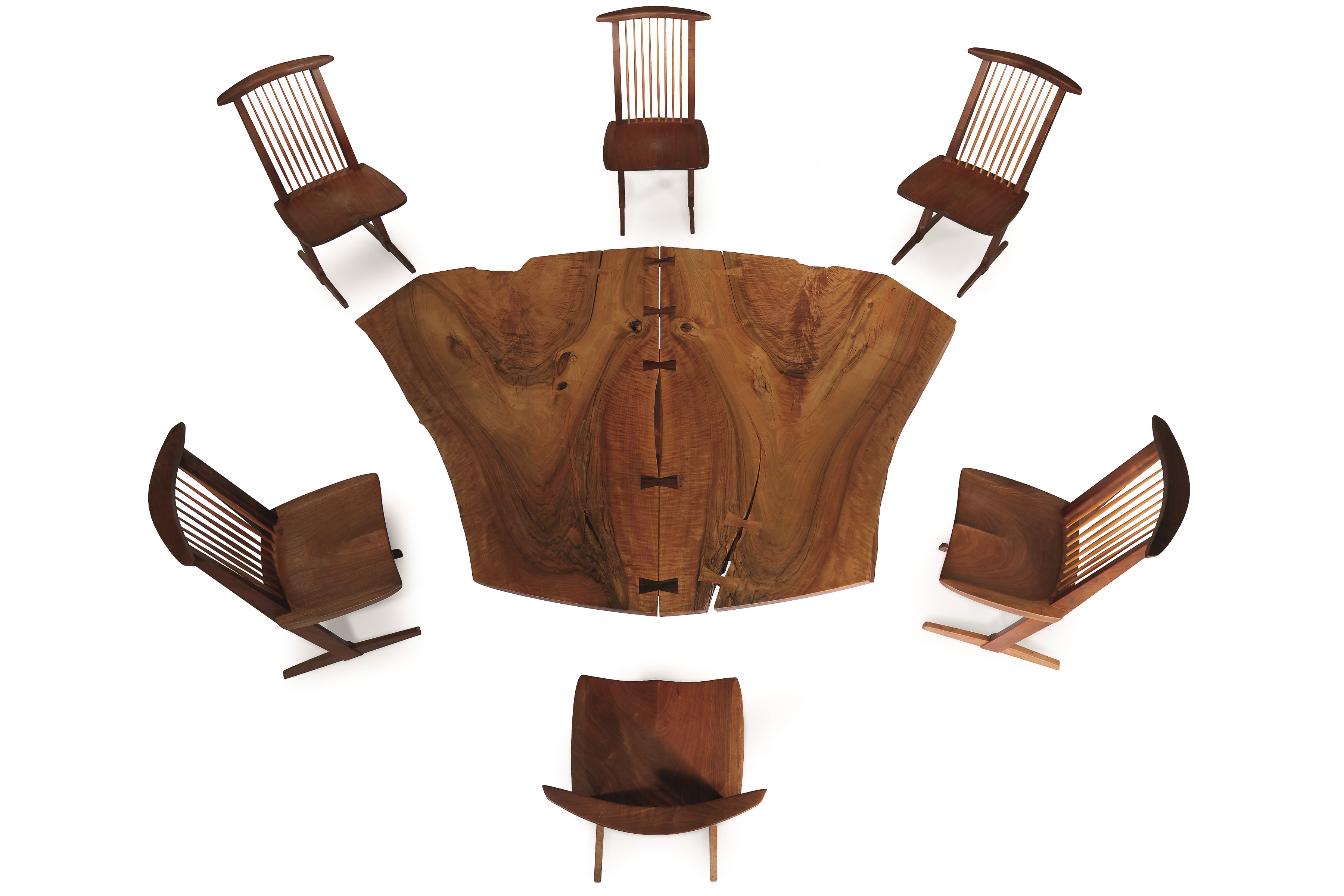 A Sanso "Reception House" table and six Conoid chairs, designed and made by George Nakashima in 1981. The table is 28 inches high, 60 inches wide, and 84 1/2 inches in diameter. All seven pieces are signed with the surname of the client.