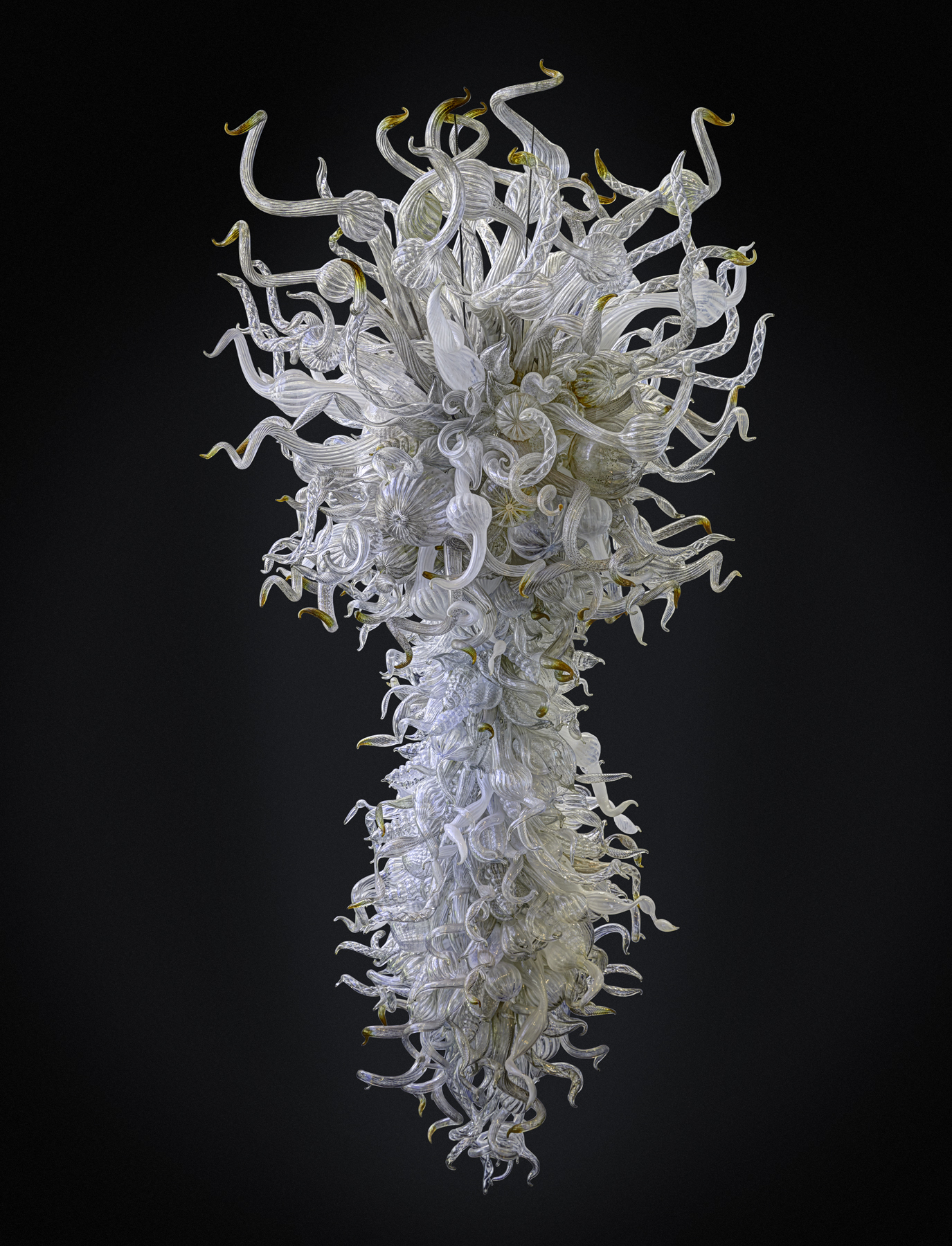A white, clear, and amber chandelier, measuring ten feet tall, five feet wide, and four feet, eight inches deep, made by Dale Chihuly in 2004. 