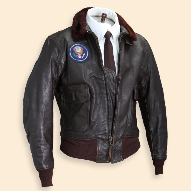 An Air Force One brown leather bomber jacket worn by President John F. Kennedy, shown in full.